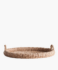 Round braided wicker tray or basket with two looped handles. The natural fibers create a warm, rustic feel. The basket's texture is tightly knit and sturdy. | SW Home