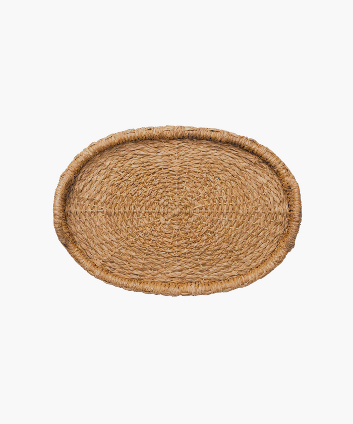 Overhead view of an oval hand-woven seagrass and rattan tray or basket with two looped handles on each side in natural brown tones. The tightly woven pattern suggests a sturdy, rustic style, suitable for home decor. | SW Home
