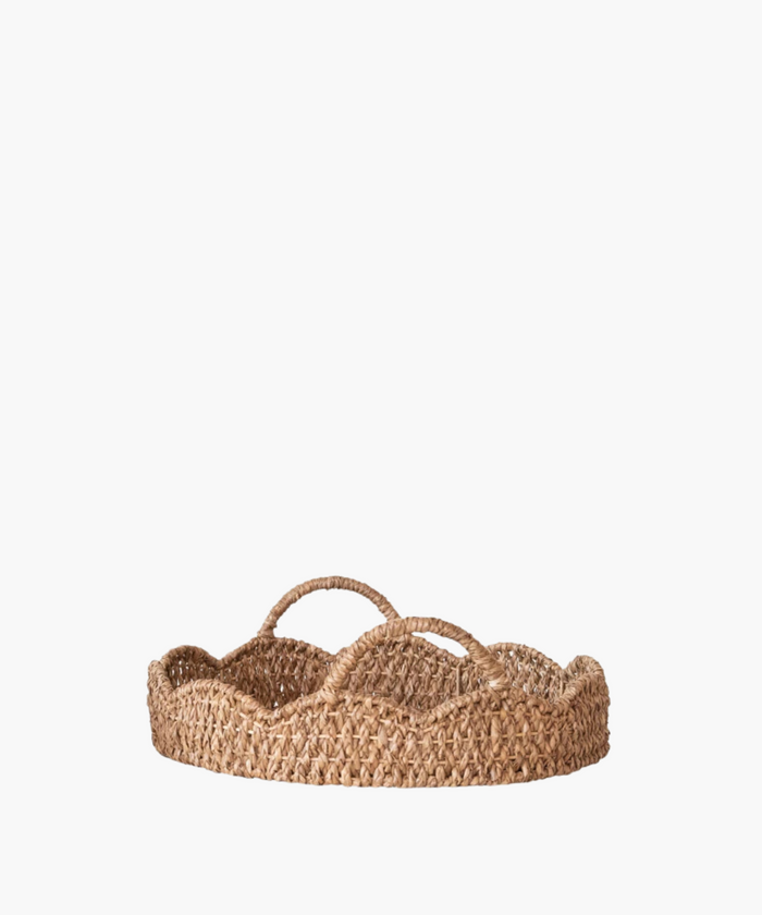 A woven, round basket with a scalloped edge and two looped handles. Made of natural fibers, it evokes a rustic and earthy aesthetic. | SW Home