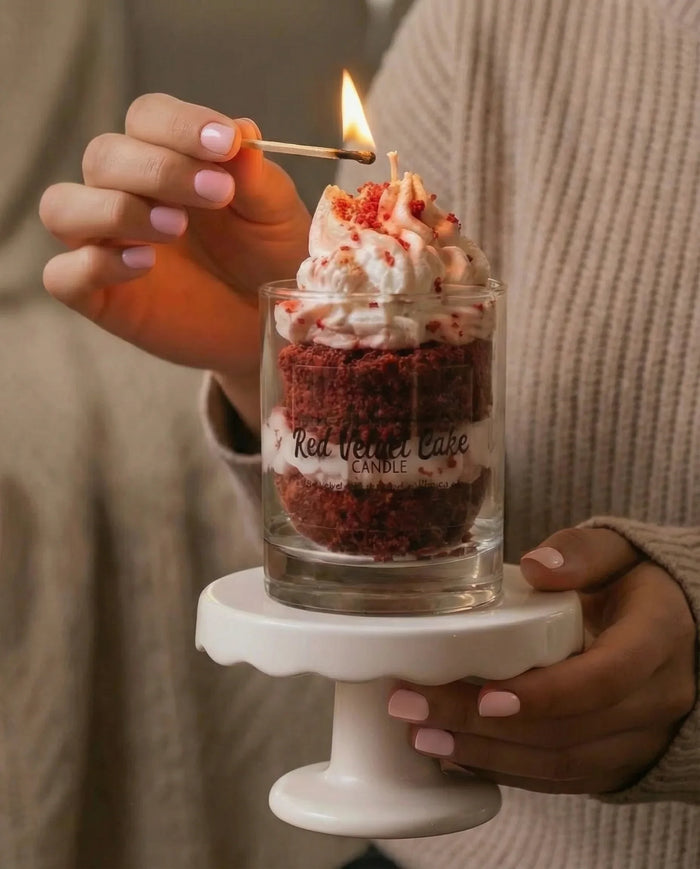 Lighting a red velvet cake scented candle topped with whipped cream design on small stand